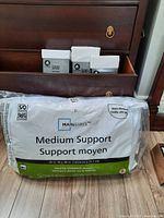 Mainstays Medium Support Pillow in original plastic packaging showing brand and size 20x28 inches, ideal for stomach sleepers.
