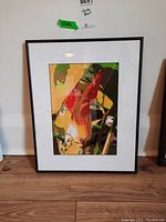 Framed giclee print titled 'Squash Come Alive' by Carl Bell leaning against a wall, showing the full front view with black frame and white matting.