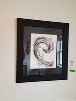 Photo of the framed limited edition lithograph print featuring an abstract swirling design in black ink on white background.