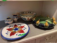 Full view of the set on a kitchen countertop showing the plate, large rooster bowl, green turtle bowl, sugar bowl, and creamer.