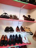 Front view of three shelves showing a variety of ladies shoes including black, brown, tan, and white colors, with a mixture of sandals and heels.