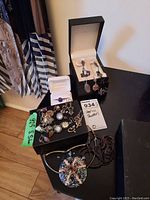 Photo showing overall lot with assorted sterling silver items including necklace with large pendant, rings, earrings, pins.