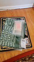 Top view showing green felt poker mat and plastic bag with playing cards and poker chips.