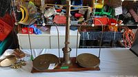 Photo showing the full large brass antique scale with two weighing pans and a wooden base.