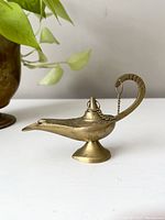 Front side view of the vintage brass genie lamp incense holder with curved handle and detailed body.