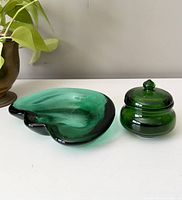 Side front view of green heart-shaped dish and round lidded Avon jar