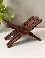 Side angled view of vintage wooden book holder showing carved details and foldable X-shape design