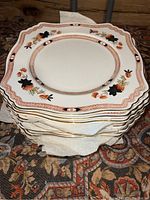 Stack of 13 Staffordshire Duchess Royal Plate plates with scalloped edges, white base, decorated in Art Deco Imari color style