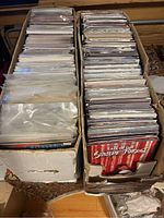 Two white long boxes each packed with bagged and boarded modern comic books.