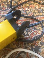 Close-up of black mounting loops and yellow metal casing of one power strip