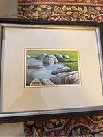 Full view of framed artwork showing rocks and water landscape