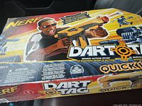 Front and top side of Nerf Dart Tag Quick 16 blaster factory sealed box showing product graphics and branding.