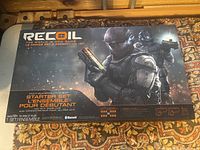 Box top displaying Recoil laser tag set branding, soldier artwork, features like multi-player, GPS enabled, and Bluetooth.
