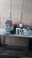 Wide view of the full lot on table showing multiple appliances