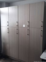 Four tall cabinets in grey woodgrain finish installed side by side