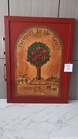 Framed print of a tree with red fruit and title text 'Purveyors to the Century' signed Crabtree & Evelyn London in red wood frame.