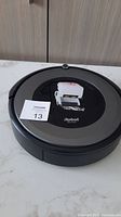 iRobot Roomba vacuum cleaner unit on countertop showing top view and condition