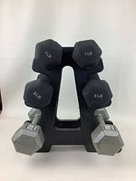 Front view of all dumbbells on black plastic stand showing 7 lb, 9 lb, and 12 lb weights