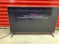 Front view of LG 42-inch Smart TV powered on showing welcome screen for setup.