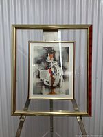 Full view of framed abstract art, glass mounted on stand.