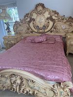 Front view of bed showing headboard, footboard, side rails and pink bedding in room setting