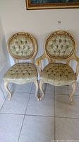 Pair of two parlor chairs with tufted upholstery, floral fabric, and carved wooden frames.