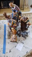 Photo showing all ceramic nativity figurines including the three wise men, baby Jesus, camel, donkey, and farm animals on a marble surface, some damage visible