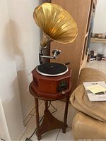 Side view of vintage-style Lawton turntable on wooden stand showing brass horn speaker and octagonal wooden base.