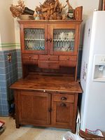 Full view of oak hutch showing upper glass-front cabinet, drawers and lower storage area