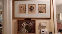 Photo of wall showing both the shadow box containing vintage memorabilia and the framed triptych above it.