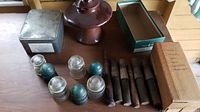 Overview of glass insulators, wooden dowels, and tin box on table