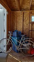 Full side view of vintage Supercycle Medalist bicycle inside a wooden shed, showing the frame, tires, and seat.