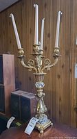 Full view of the gold tone metal and stone candelabra holding four taper candles, showing overall ornate design and structure.