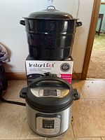Front view of Instant Pot and black speckled canning pot with lid showing size and condition.