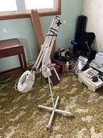 Full view of the white magnifying lamp on caster base with folding arm extended