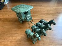Full view of the replica chariot with four horses and driver on a wooden floor.