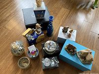 Wide view of collection with cottages, vases, mosaic decor, figurines, and crystal items arranged on floor