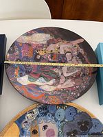 Top view of circular porcelain wall mural showing full design and tape measure indicating diameter