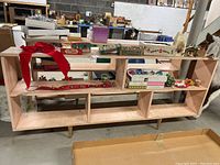 Full front view of the rectangular bookshelf with several open compartments and some holiday decor items resting on it.