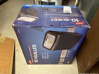 Photo of the Staples shredder in its original blue box showing capacity to shred 10 sheets, cross-cut type.