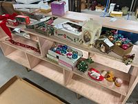 Shelf with multiple boxes and loose vintage Christmas ornaments in Shiny Brite boxes, various colors and styles, and additional holiday decoration pieces