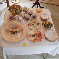 Full view of collection showing multiple china pieces including cups, plates, and decorative fruit baskets.