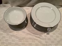 Stack of 12 bowls on left and 12 plates on right, showing overall quantity and matching pattern