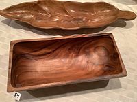 Both wooden serving platters shown, leaf-shaped one on top and rectangular below, highlighting the natural wood grain and finish.