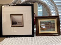 Front view of large black framed and matted 7x7 photo of foggy harbor scene alongside smaller framed Monet print
