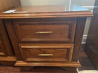 Front view showing two drawers with brass handles and wood panel detailing.
