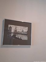 Framed black and white print showing a harbor with boats and buildings, signed by Bernard Buffet.