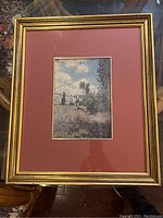 Framed Claude Monet print with red matte and gold-toned frame showing the full piece.