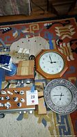 Photo shows the clocks, mini Delft figurines, boxed items, and part of the Sangean radio on a rug.
