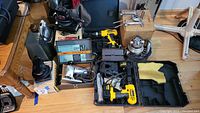 Overview of lot showing two DeWalt drills in case, Craftsman router, sander, RAM jigsaw, Black & Decker planer box